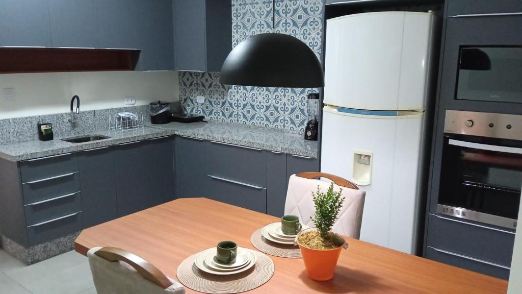 a kitchen with a wooden table with chairs and a dining room at Edifício Master in Cascavel