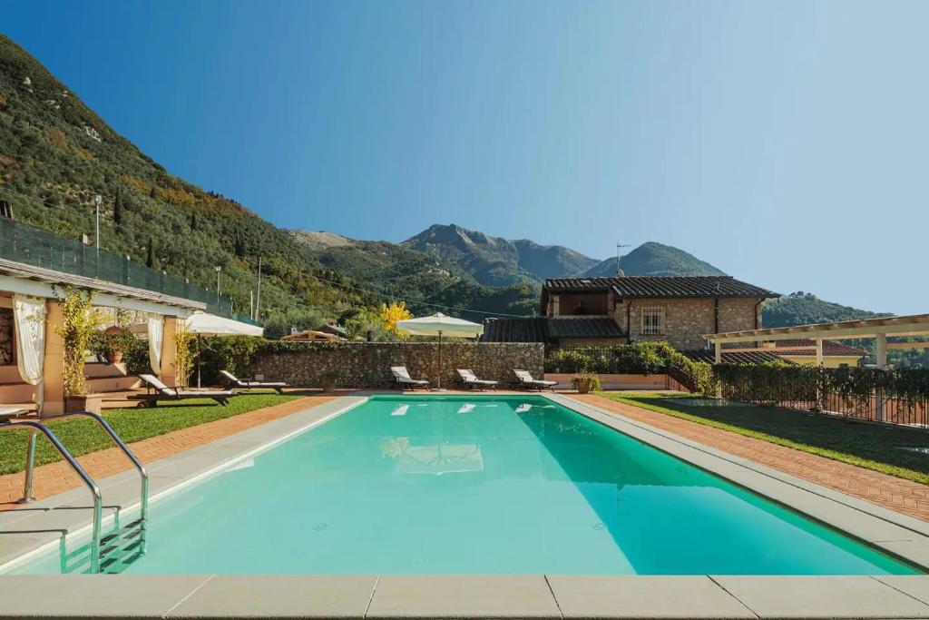 a swimming pool in a yard with mountains in the background at Villa Melangola in Camaiore