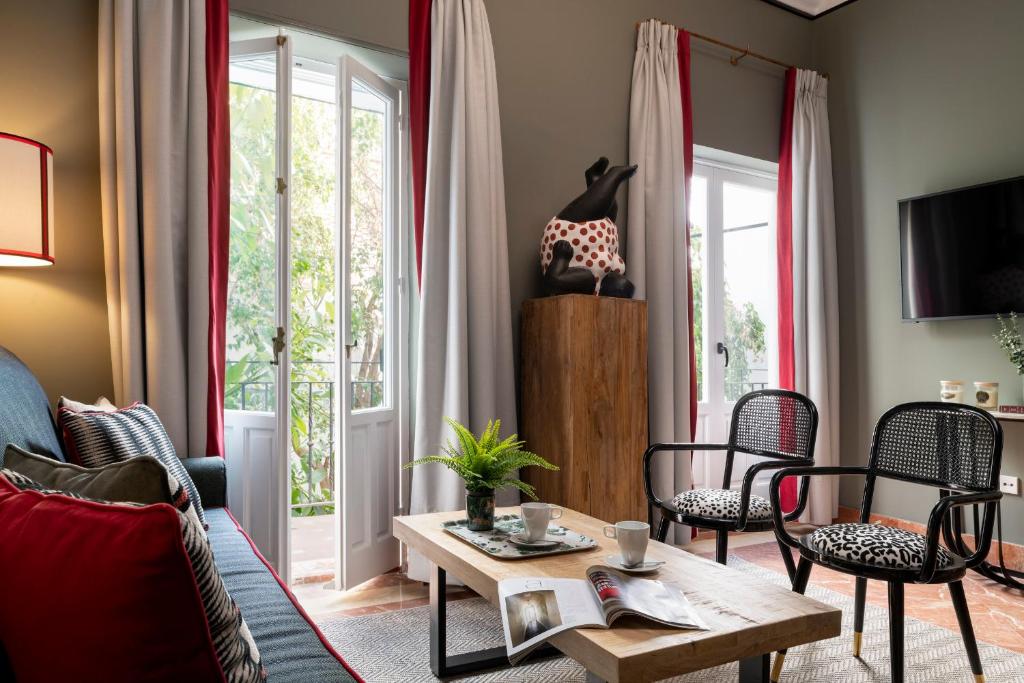 a living room with a couch and chairs and a table at PUERTA DE ARMAS APARTMENTS in Seville
