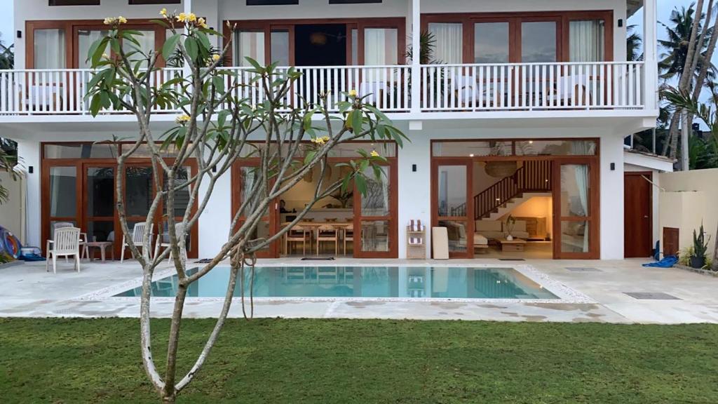 une maison avec une piscine en face de celle-ci dans l'établissement Lihinya Beach Villa Ahangama, à Ahangama