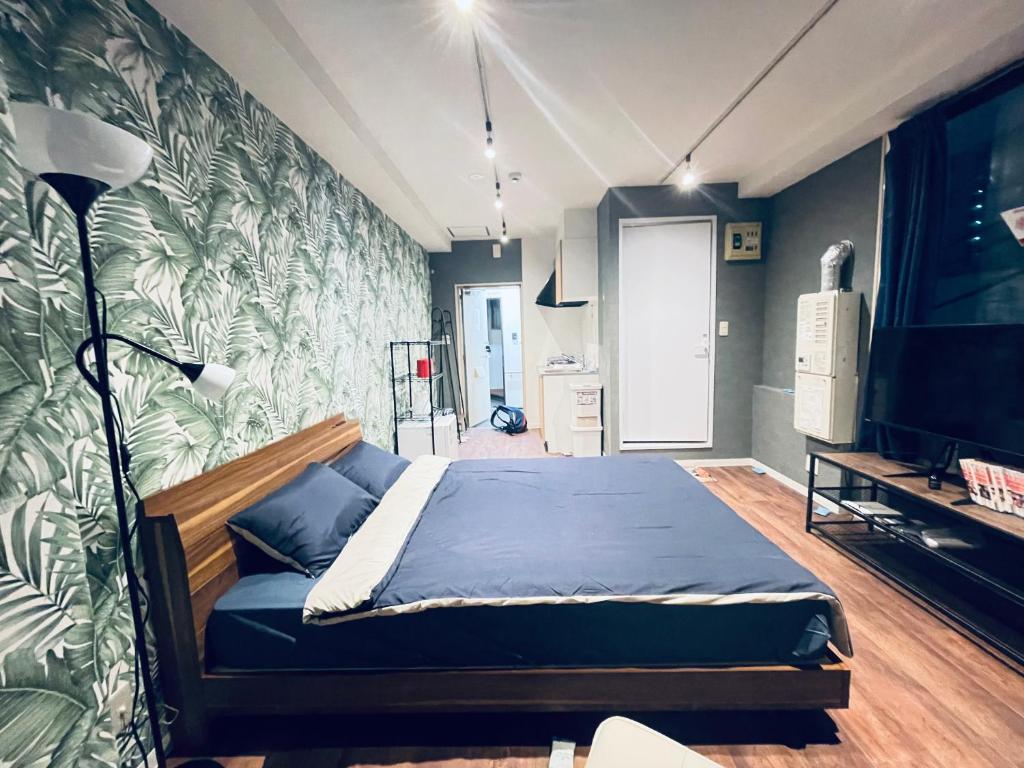 a bedroom with a bed and a wall with plants at 301门前仲町两分钟步行 全新宽敞公寓 两条地铁直达新宿东京上野 in Tokyo