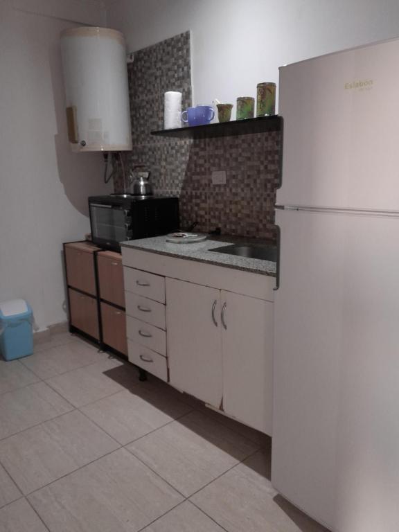 una cucina con frigorifero bianco e forno a microonde di DEPARTAMENTO PARA DOS PERSONAS EN ZONA CENTRICA a Zárate