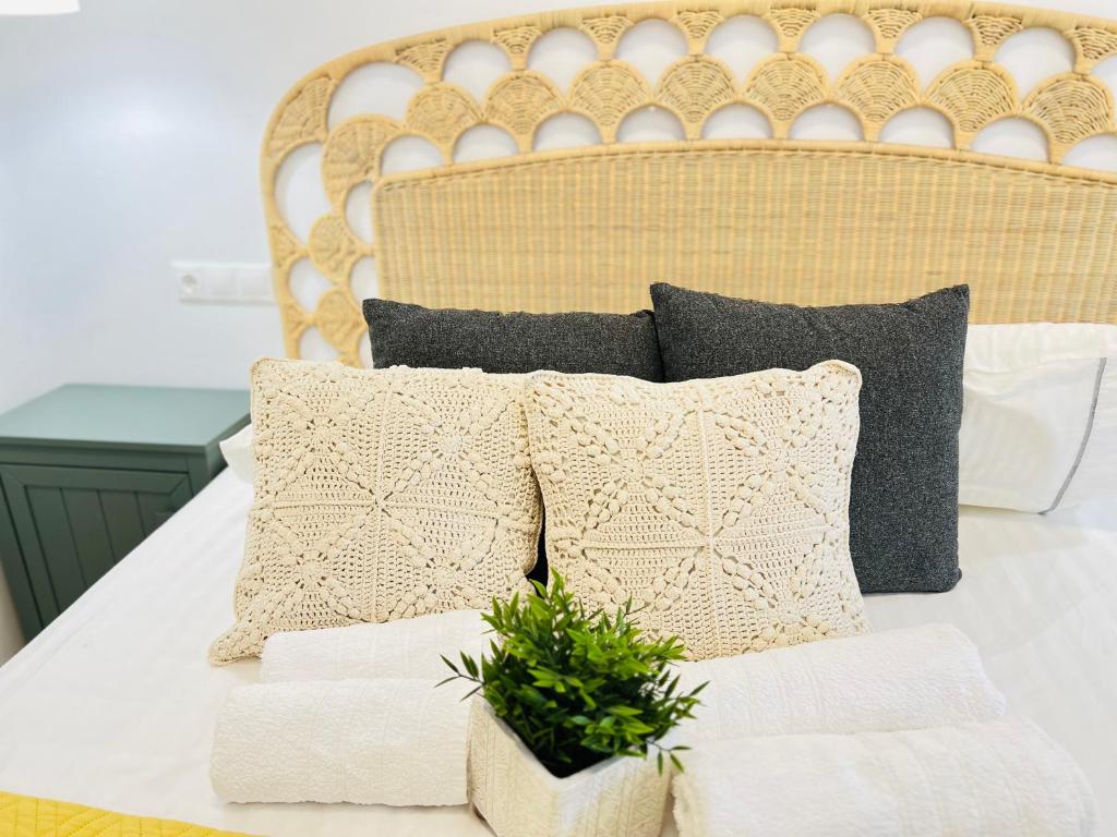 a bed with pillows and a plant on it at Gerani Deluxe Houses in Astypalaia