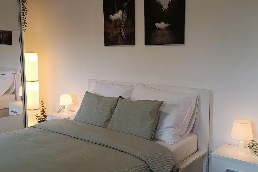 een slaapkamer met een bed met 2 lampen en een spiegel bij Plitvice Green Apartment in Plitvička Jezera