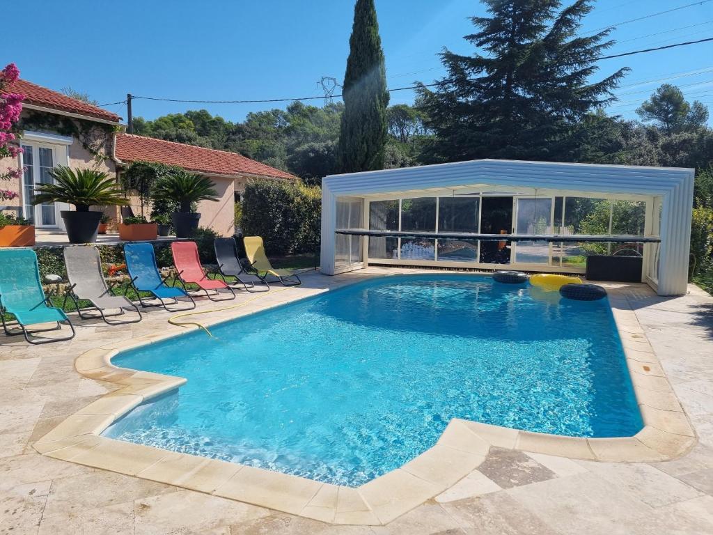 una piscina con sillas y una casa en Petite pause à la campagne, en Sainte-Anastasie-sur-Issole