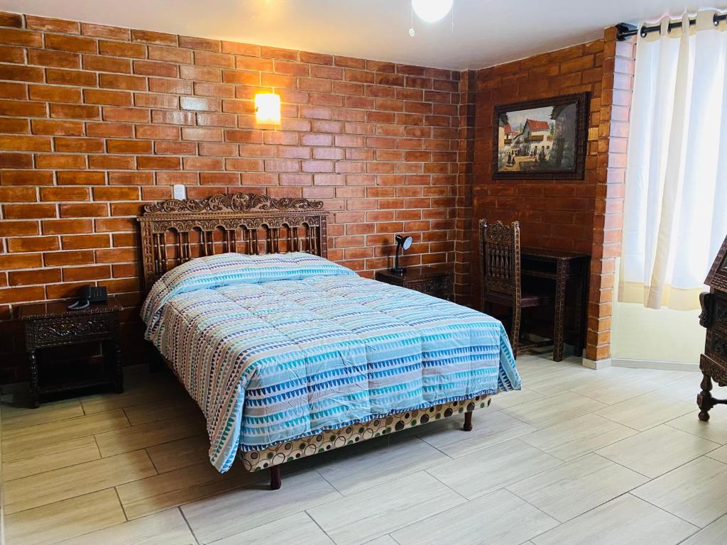 um quarto com uma cama e uma parede de tijolos em Hotel Esperanza em Lima