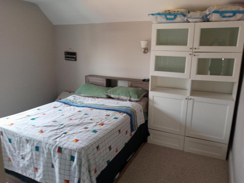 1 dormitorio pequeño con 1 cama y armario blanco en Private Room AIR BNB, en Peterborough