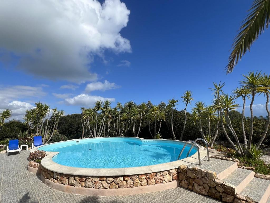 a large swimming pool with a stone wall around it at 233 Casa Galo Verde Apartments in Porches