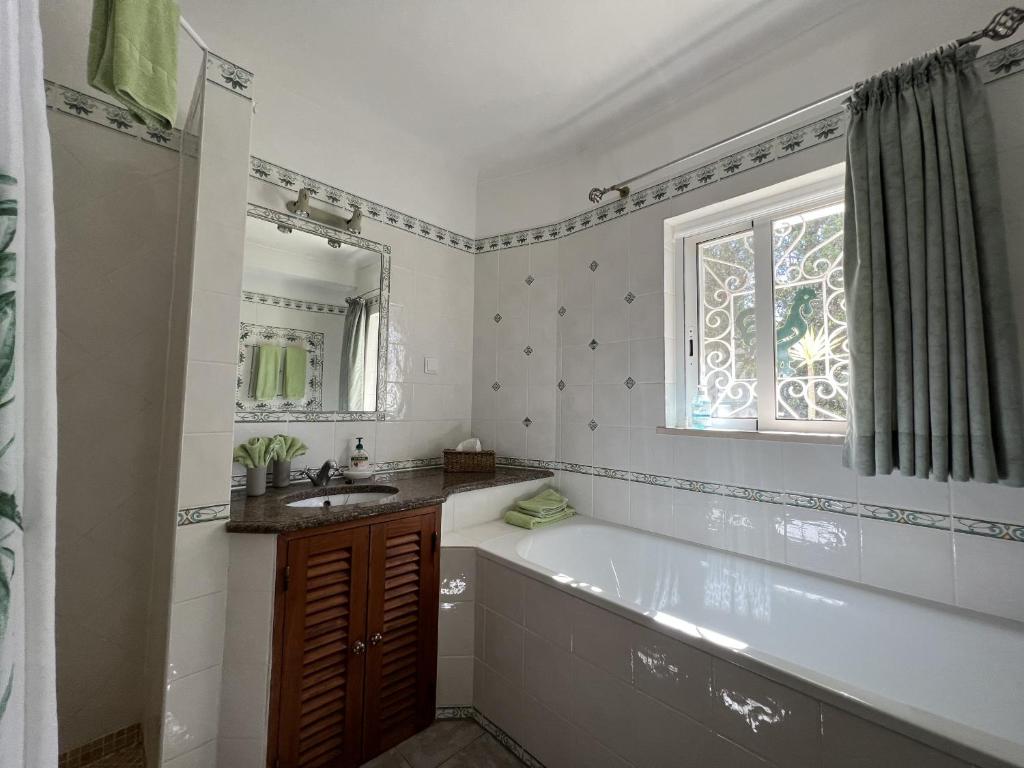 a bathroom with a tub and a sink and a window at 233 Casa Galo Verde Apartments in Porches