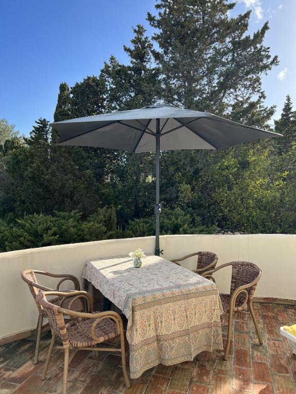 a table and chairs with an umbrella on a patio at 233 Casa Galo Verde Apartments in Porches