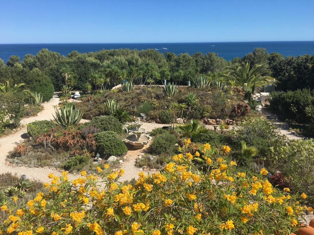 a garden with flowers and the ocean in the background at 233 Casa Galo Verde Apartments in Porches