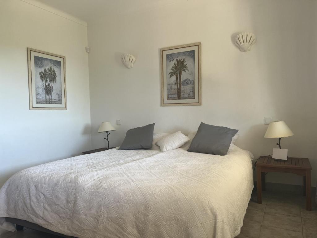 a bedroom with a bed with two lamps and two tables at 233 Casa Galo Verde Apartments in Porches