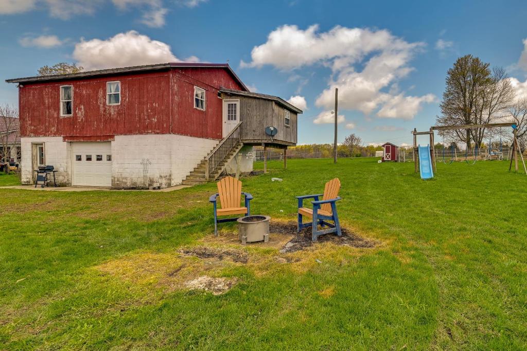 two chairs sitting in a field next to a barn at Upstate New York Vacation Rental Near Cooperstown! in Cherry Valley