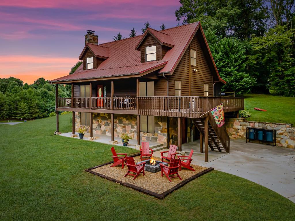 une grande maison avec des chaises rouges et une terrasse dans l'établissement Mountain Valley Lodge Gatlinburg Wears Valley P Forge, à Sevierville