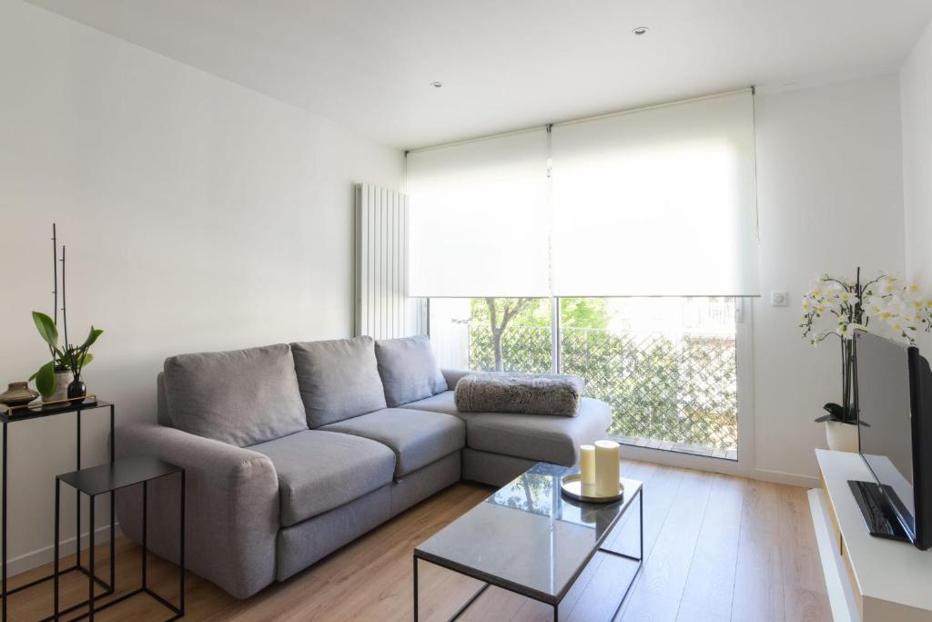 uma sala de estar com um sofá e uma mesa em Calm and modern flat in Boulogne-Billancourt - Welkeys em Boulogne-Billancourt