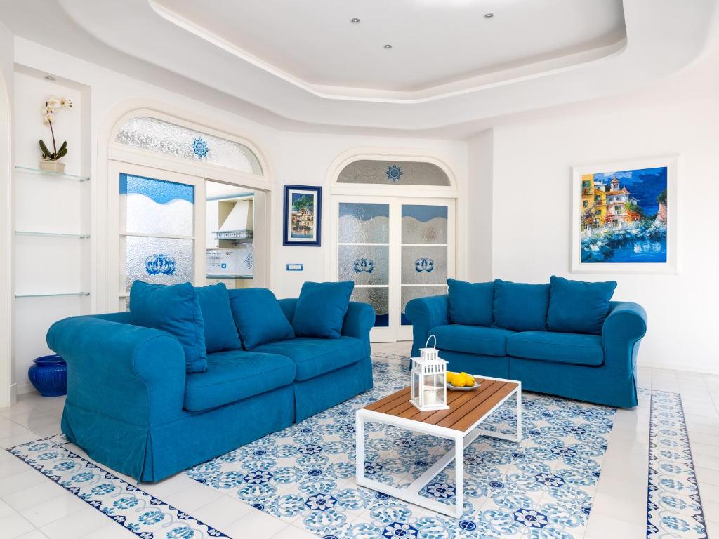 ein Wohnzimmer mit blauen Sofas und einem Tisch in der Unterkunft La Casa di Terry - Breathtaking view of Sorrento in Sorrent