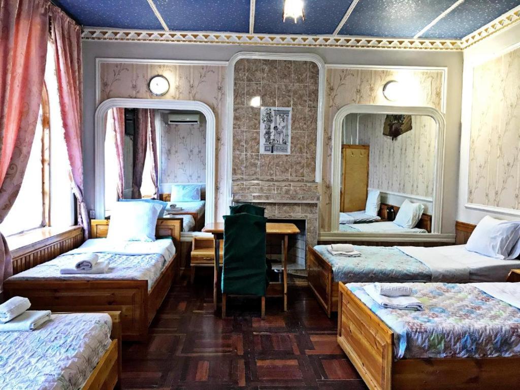 um quarto com quatro camas e um espelho em Hotel KAMILA Prime em Samarkand
