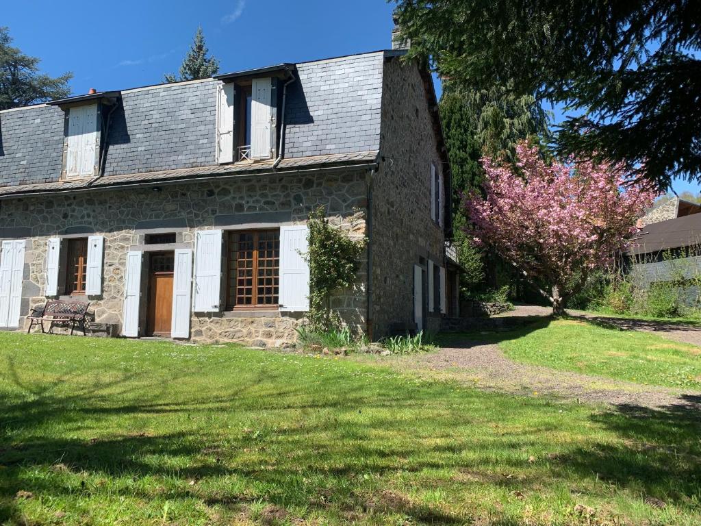 an old stone house on a grass field at Charmant appartement jardin/parking privé 4 personnes in La Bourboule