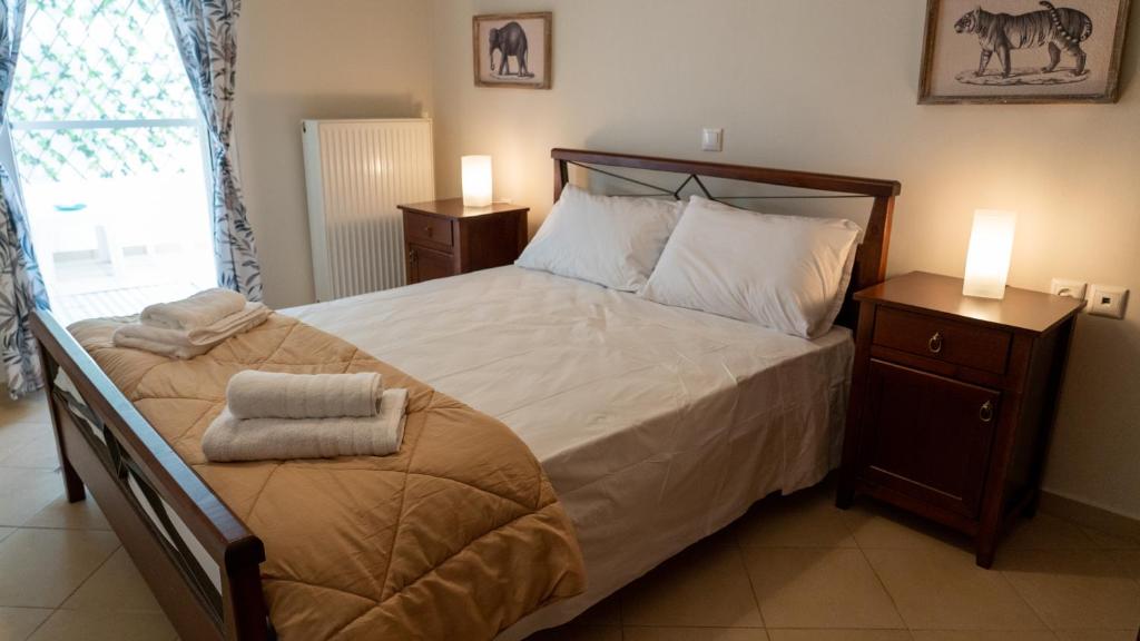 a bedroom with a large bed with two night stands at Magda's garden home. in Galatás