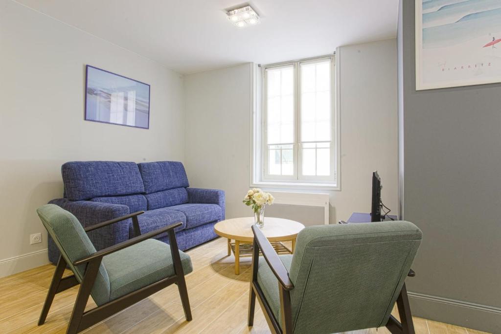 Nice flat 300 meters away from the beach - Biarritz - Welkeys في بياريتز: غرفة معيشة مع أريكة زرقاء وطاولة
