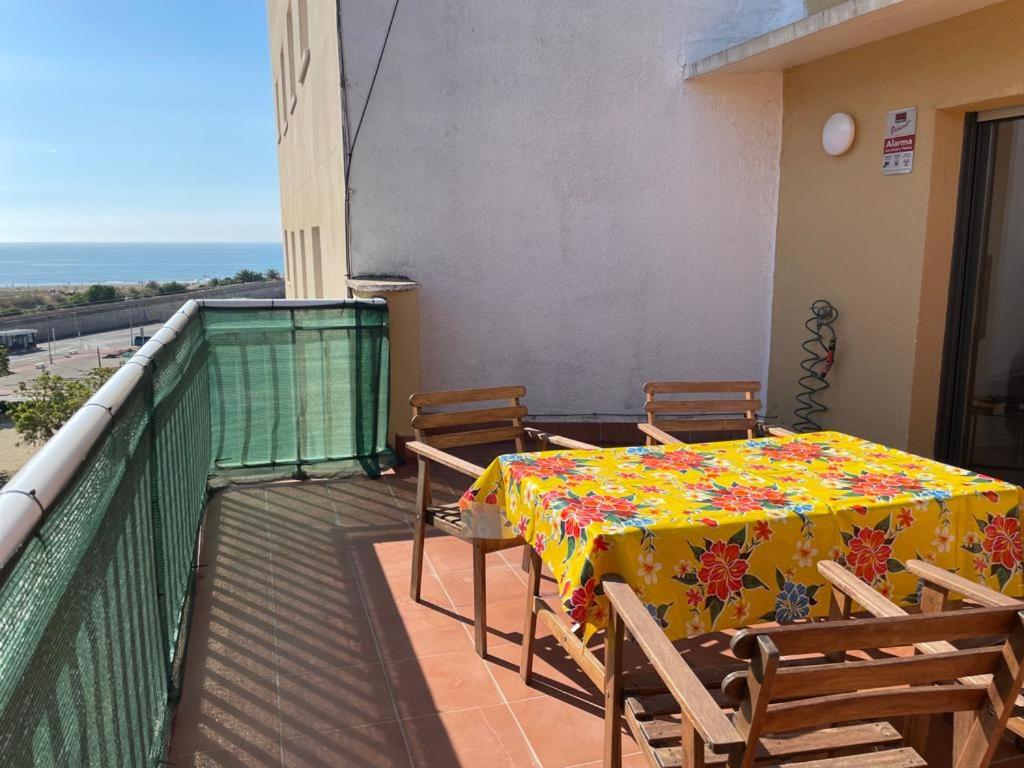 een tafel en stoelen op het balkon van een gebouw bij Apartamento en Vilanova i la Geltrú in Vilanova i la Geltrú