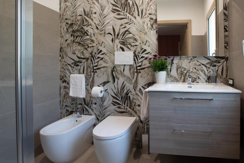 a bathroom with a toilet and a sink at Tarsis Guest House in Baunei