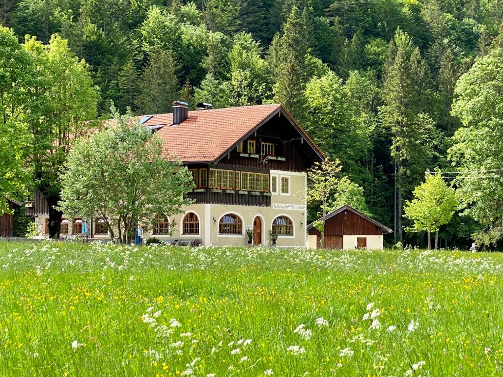 a house in the middle of a field of grass at Ferienwohnungen Zipflwirt in Bayrischzell