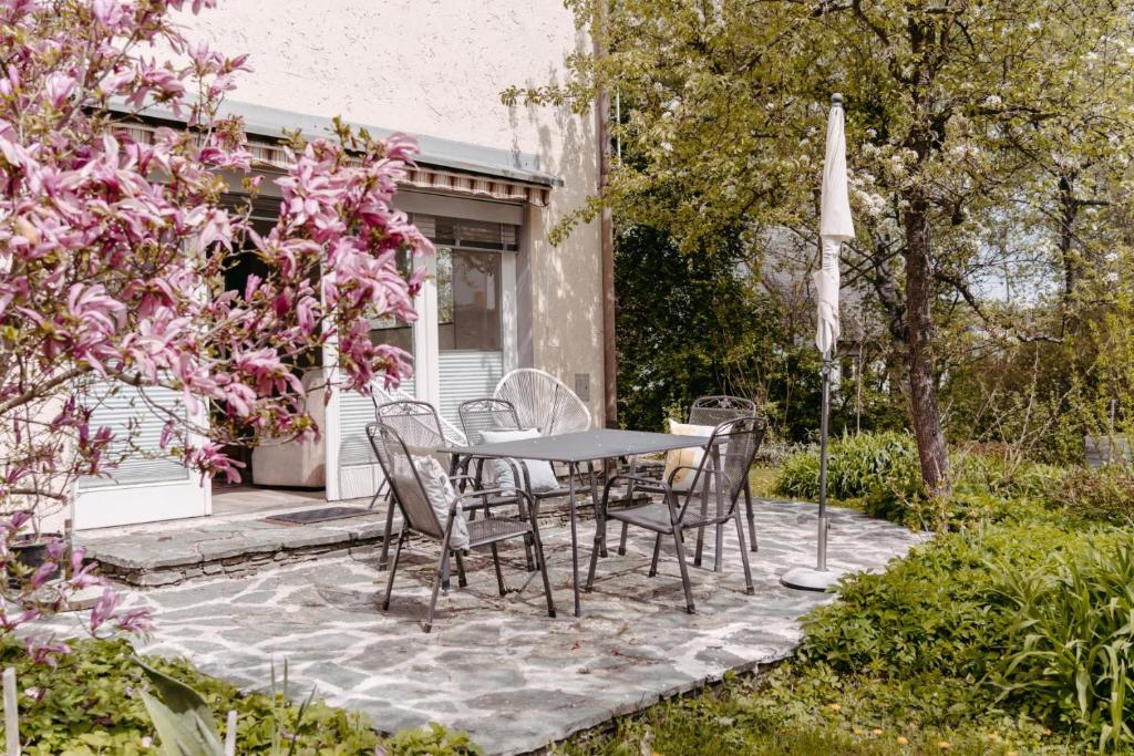 a patio with a table and chairs in a garden at Apartments Obir am Wörthersee in Krumpendorf am Wörthersee