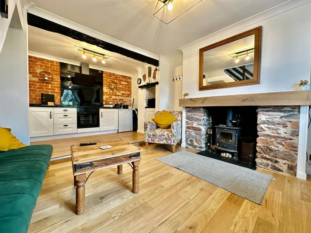 a living room with a fireplace and a green couch at Cosy cottage with character. in Brixham