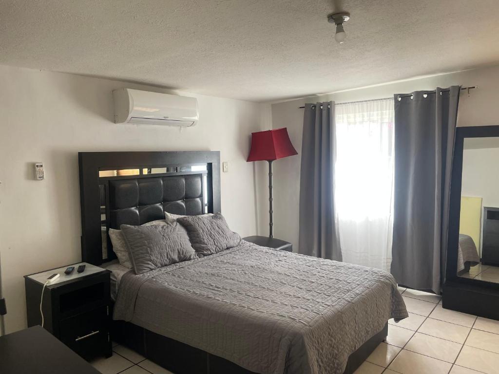 Un dormitorio con una cama grande y una ventana en Departamento privado con cochera y WIFI alta velocidad, en Chihuahua