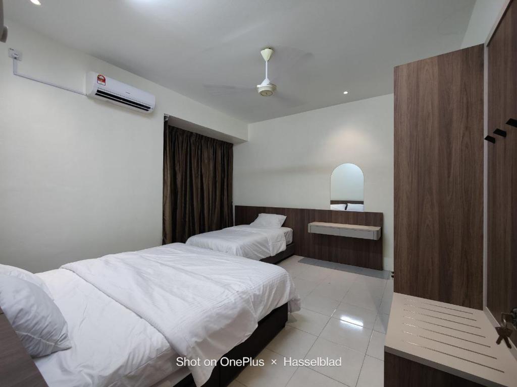 una camera d'albergo con due letti e un lavandino di GEYI HOMESTAY a Jerantut