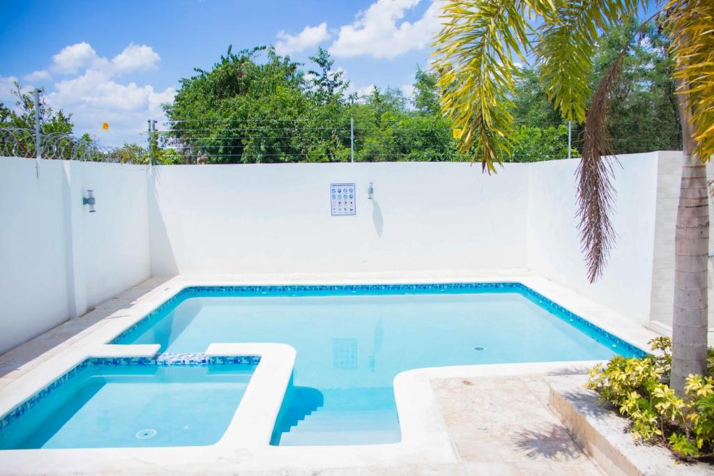 uma piscina ao lado de uma cerca branca com uma palmeira em 3 BR apartment ciudad santiago de los caballeros em Santiago de los Caballeros