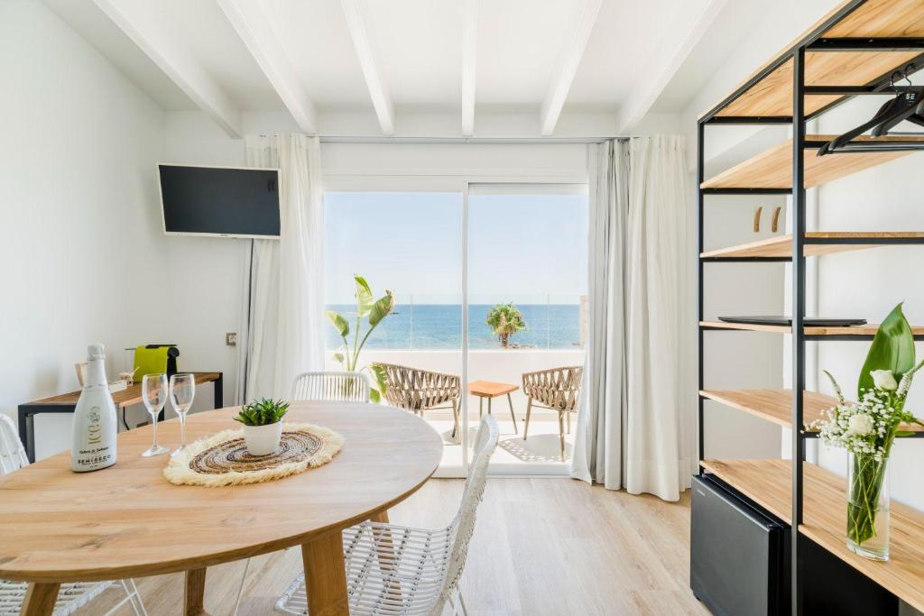 a dining room with a table and a view of the ocean at Outsite Ibiza in Es Cana