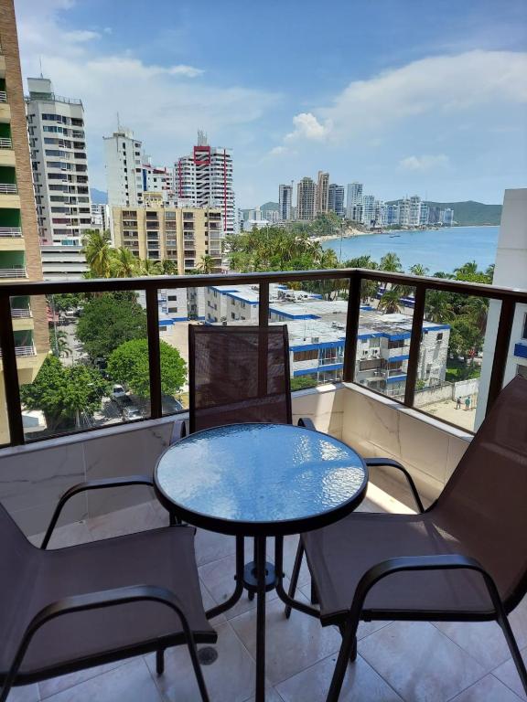a balcony with a table and chairs and a view of the ocean at Apartamento VISTA AZUL RODADERO LAURELES 801 in Rodadero