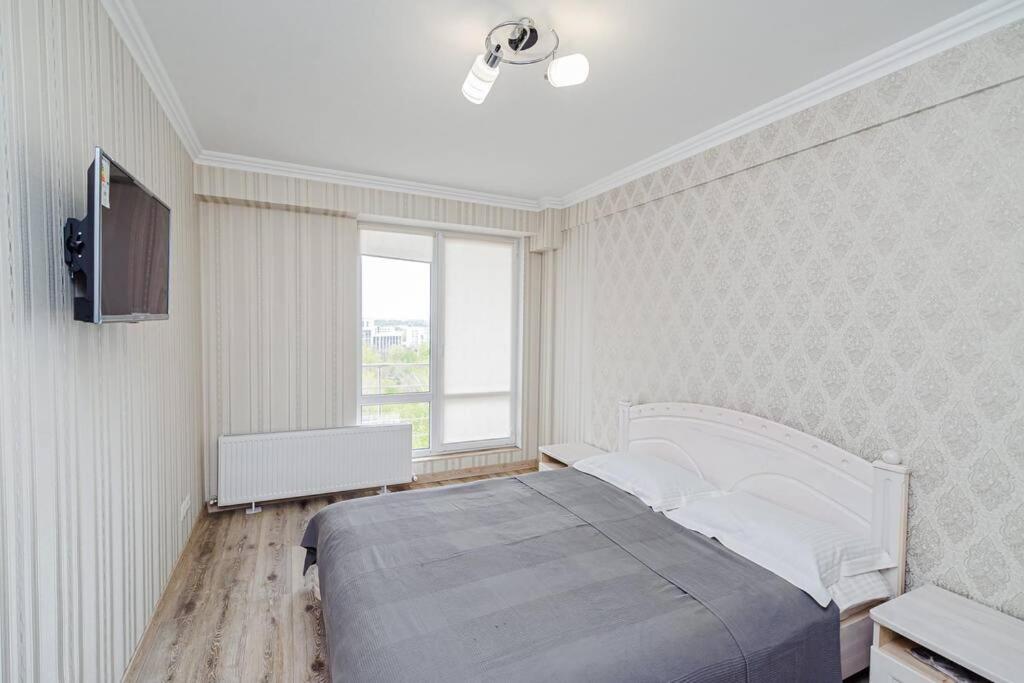 Un dormitorio con una cama grande y una ventana en Apartament cu vedere la parc, en Chişinău