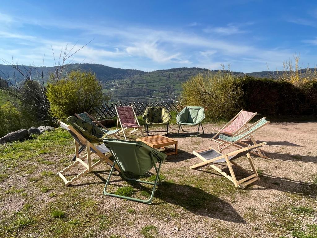 eine Gruppe von Gartenstühlen auf einem Hügel in der Unterkunft Chalet Les Sapins sauna au pied des pistes in La Bresse