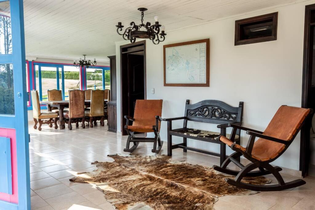 ein Wohnzimmer mit Stühlen, einem Tisch und einem Teppich in der Unterkunft Espectacular casa de montaña in Pereira