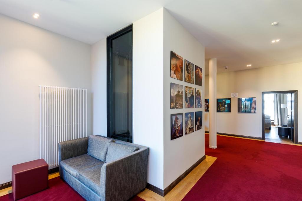 a living room with a chair and a wall with pictures at Hotel Alte Post in Konstanz