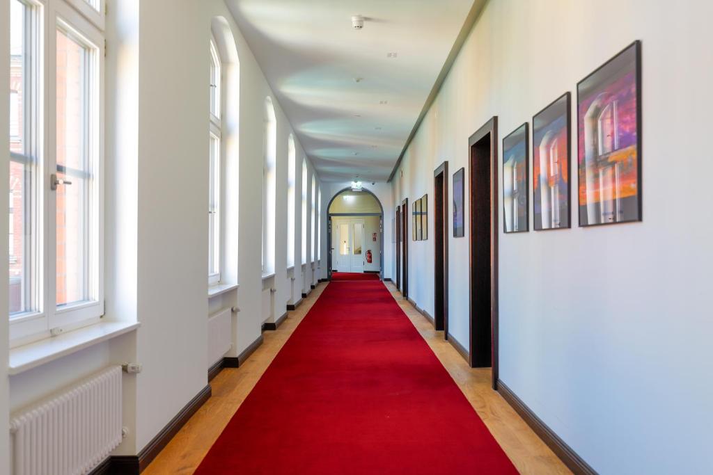 a long hallway with a red carpet and windows at Hotel Alte Post in Konstanz