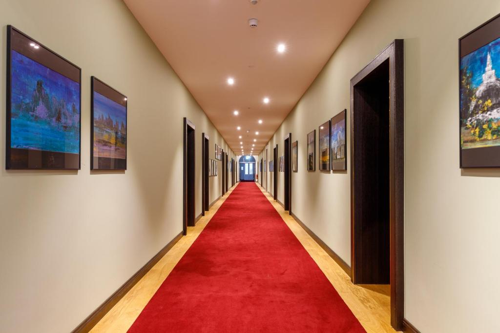 a long hallway with a red carpet and paintings at Hotel Alte Post in Konstanz