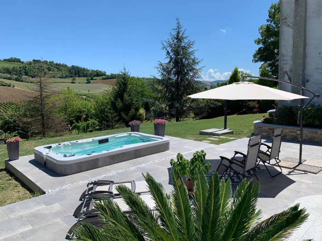a swimming pool with chairs and an umbrella at B&B Casa Favari in Montalbo