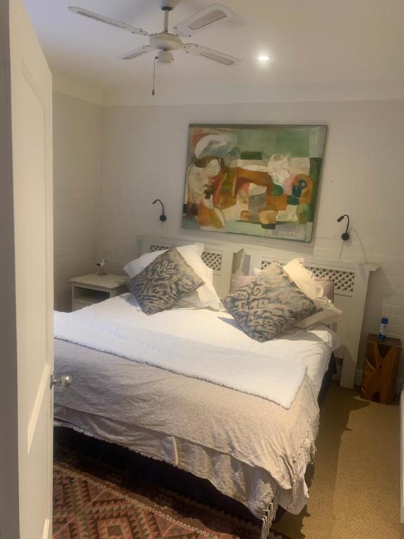 a bedroom with a bed with a painting on the wall at Villa Paulina Family suite in Langebaan