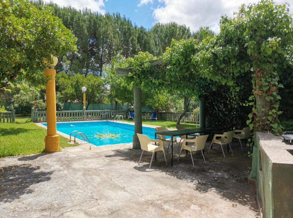 a patio with a table and chairs next to a pool at Labriega del hueznar in Cazalla de la Sierra