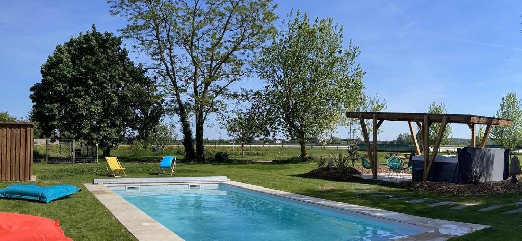 a swimming pool in a yard with a gazebo at Gite au gré de la Loire piscine et spa in Saint-Mathurin