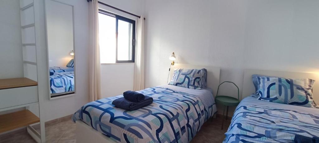 アルブフェイラにあるCasa "Os Amados"の小さなベッドルーム(ベッド1台、鏡付)