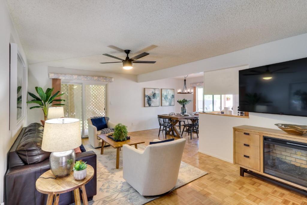 a living room with a couch and a tv at 5 Mi to Ocotillo Golf Course Chic Sun Lakes Home! in Sun Lakes