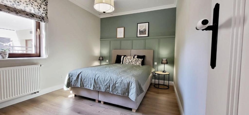 una camera con un letto e una croce sul muro di Komfortowy Apartament Przy Bramie Targowej z tarasem- Old Town a Elblag
