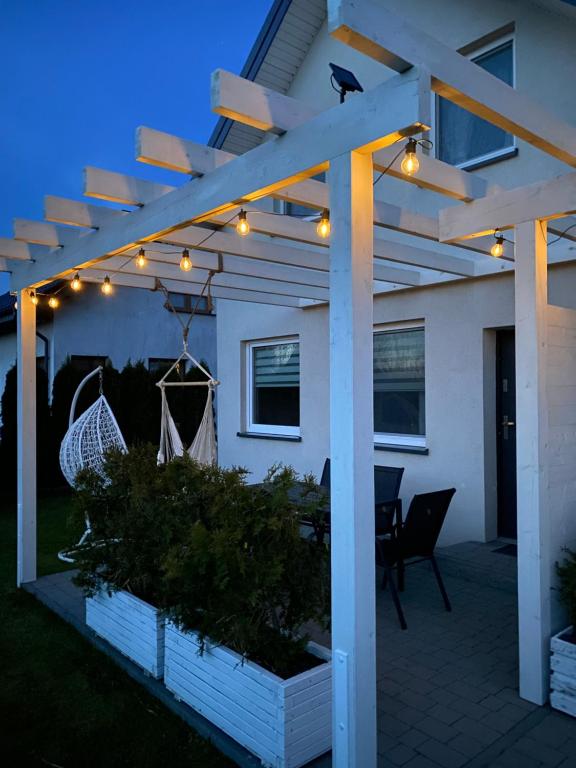a pergola with lights on a patio at Domki Akacjowe Zacisze in Puck