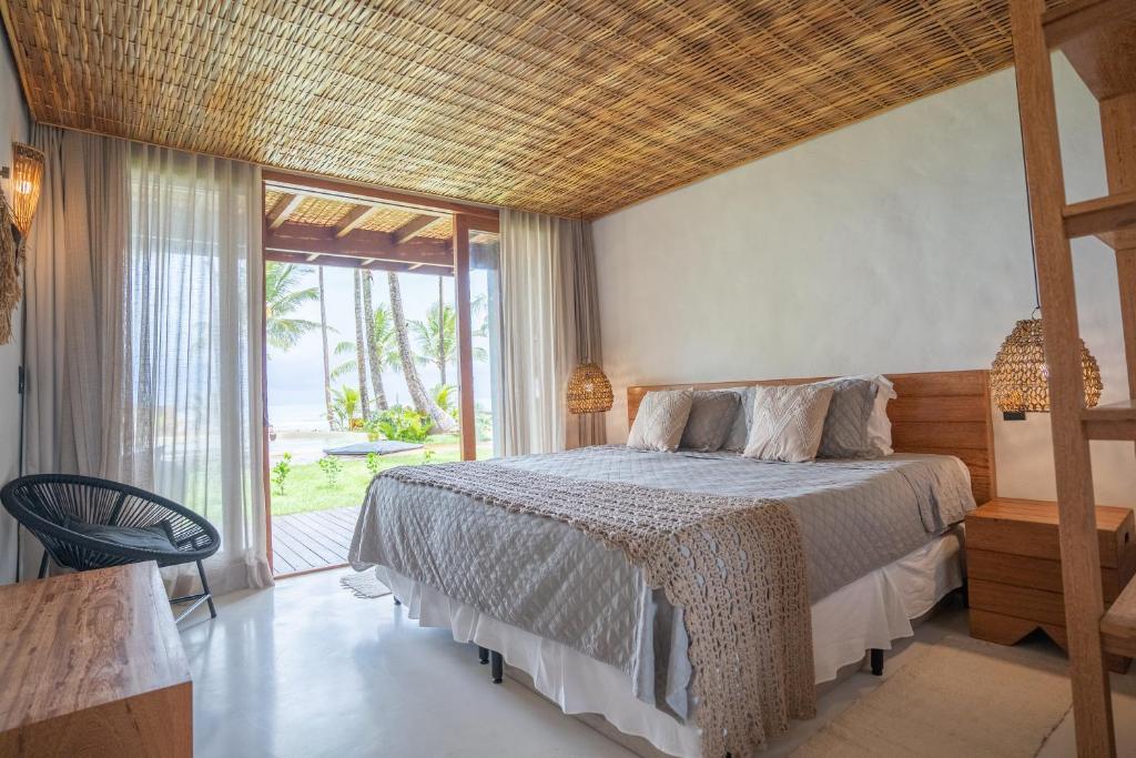 a bedroom with a bed and a large window at Villa Kandui Boutique Hotel e Beach Lounge in Barra Grande