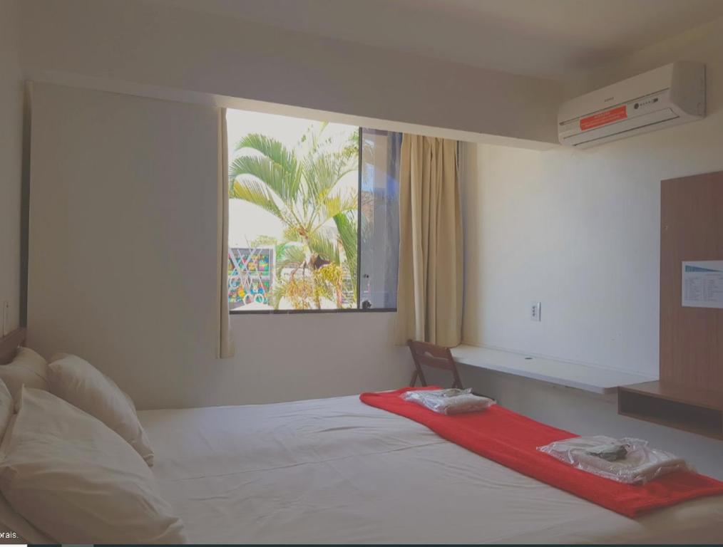 um quarto com uma cama com um cobertor vermelho em Pousada Suites em Brasília
